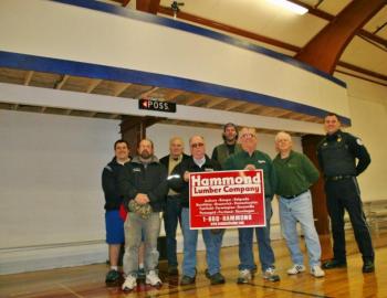 Standing below the YMCA's new scorer's roost are some of the instrumental people in getting the new feature built. From left are, front row: Scott Bennett, Harold Buzzell and Tom Nickerson of Hammond Lumber, Neal Verge; back row: Eddie Crocker, Bill Haney, Jonn Trees and Bob Hasch. KEVIN BURNHAM/Boothbay Register Standing below the YMCA's new scorer's roost are some of the instrumental people in getting the new feature built. From left are, front row: Scott Bennett, Harold Buzzell and Tom Nickerson of Hammond Lumber, Neal Verge; back row: Eddie Crocker, Bill Haney, Jonn Trees and Bob Hasch. KEVIN BURNHAM/Boothbay Register