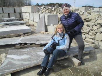 Jennifer Litchfield, left, and Donna Dennison of Boothbay Region Arts Foundation try out Jim Taliana's future memory bench at J.C. Stone rock quarry. Courtesy of Barbara Eldred