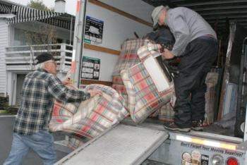 York Fischer, left, and Ted Repa load some stuffed chairs into the truck at the Rocktide Inn on Thursday, May 23. KEVIN BURNHAM/Boothbay Register 