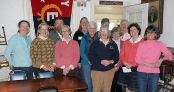 Barbara Rumsey, front (dark jersey), is surrounded by Historical Society volunteers during the gathering to honor her on April 25. Courtesy of Betsy Spekke