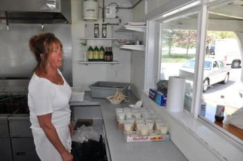 Bet Finocchiaro serves up some fried fish and potatoes May 28 at Bet's Famous Fish Fry in Boothbay. Finocchiaro has been selling just fried fish and potatoes for the last 20 years and said her secret isn't in the sauce but in hard work. BEN BULKELEY/Boothbay Register