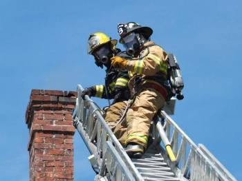 Boothbay firefighter David Steinmetz, top, and Boothbay Harbor firefighter Dan Gagnon stand by on the ladder truck during a minor chimney fire at Linekin Bay Bed & Breakfast, May 15. RYAN LEIGHTON/Boothbay Register