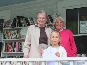 Friends President Jean Dube, left, and volunteer Carolyn Mayne, right, congratulate Hattie Moss, foreground, who won the Used Bookstore’s dove naming contest and a $25 gift certificate to the bookstore. Moss named momma bird “Booksen.” SUE MELLO/BoothbayRegister. Friends President Jean Dube, left, and volunteer Carolyn Mayne, right, congratulate Hattie Moss, foreground, who won the Used Bookstore’s dove naming contest and a $25 gift certificate to the bookstore. Moss named momma bird “Booksen.” SUE MELLO/BoothbayRegister.