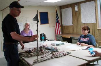 Edgecomb Fire Chief Roy Potter holds up one of the fragmented flags he found at a cemetery Memorial Day morning. Also pictured are selectmen's secretary Jen Elkins, left, and Selectman Jessica Chubbuck. SUSAN JOHNS/Wiscasset Newspaper