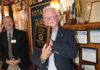 George H. McEvoy holds the Lifetime Service Award plaque he received from the Boothbay Harbor Rotary Club June 13. Below: Ted Foss and Ben English. KEVIN BURNHAM/Boothbay Register George H. McEvoy holds the Lifetime Service Award plaque he received from the Boothbay Harbor Rotary Club June 13. KEVIN BURNHAM/Boothbay Register