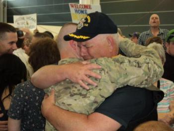 Peter Greenleaf hugs his son, Pvt. Nick Greenleaf, upon his return to Maine June 15. Below: The Greenleaf and Leighton families hold signs welcoming their soldiers home from Afghanistan; Pvt. Mason Leighton talks with his father, Micheal Leighton, and family friend, Patrick Higgins. Courtesy of Isaac Luken Peter Greenleaf hugs his son, Pvt. Nick Greenleaf, upon his return to Maine June 15. Courtesy of Isaac Luken