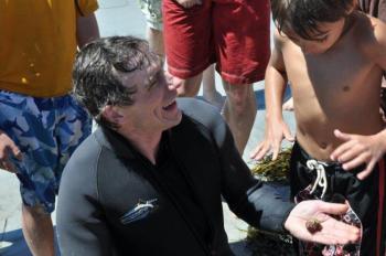 A hermit crab rests on Brian Boone's hand while onlookers get a better look at the bounty the diver pulled from the water. Boone was able to pull out a variety of creatures from a short dive. BEN BULKELEY/Boothbay Register A hermit crab rests on Brian Boone's hand while onlookers get a better look at the bounty the diver pulled from the water. Boone was able to pull out a variety of creatures from a short dive. BEN BULKELEY/Boothbay Register