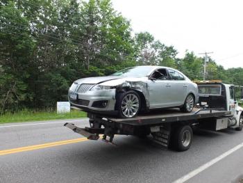 A Lincoln Towncar that collided with a dumptruck is towed away from the accident scene. RYAN LEIGHTON/Boothbay Register