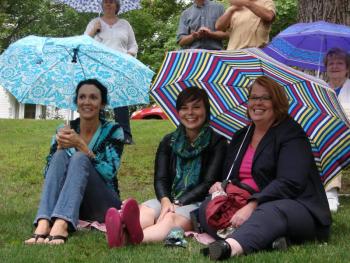Wiscasset Area Chamber of Commerce board vice chairman Sherri Dunbar, left, Hope Mowry of Auburn and Wiscasset Town Manager Laurie Smith take the rain in stride at Lynn Deeves' installment of the “Alive on the River” concert series. Last week's concert overlapped with the Wiscasset Art Walk, providing one more thing for visitors to enjoy. SUSAN JOHNS/Wiscasset Newspaper