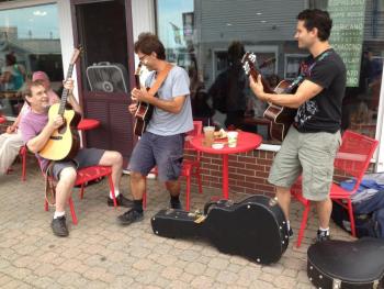Outside of Red Cup Coffeehouse, owner/musician Paul Johnson (left) jams with jazz guitar legends Frank Vignola and Vinny Raniolo. JOE GELARDEN/Boothbay Register
