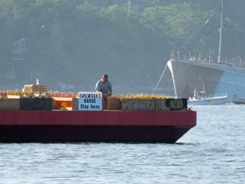 Pyrotechnic Austin Hills prepares for the Fourth of July fireworks show aboard the barge in Boothbay Harbor.  GARY DOW/ Boothbay Register