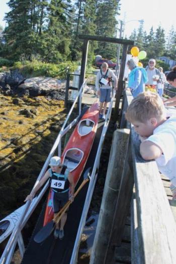 A young boy watches as kayaks are carried down to the dock on August 10. SUE MELLO/Boothbay Register