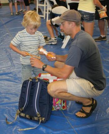 High school teacher and coach Bryan Dionne helps his son load a handful of new pencils into his new backpack. KEVIN BURNHAM/Boothbay Register