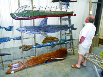 Dan Biron of Lee, N.H. admires the folk art of Souhport's Mike Lewis at Lincoln Art Festival's Arts & Yachts show held at the Boothbay Region Boatyard. GARY DOW/Boothbay Register Dan Biron of Lee, N.H. admires the folk art of Souhport's Mike Lewis at Lincoln Art Festival's Arts & Yachts show held at the Boothbay Region Boatyard. GARY DOW/Boothbay Register
