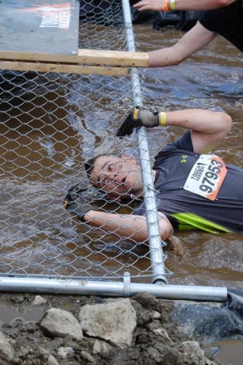 Jared Mitkus enters the mud pool/chain link fence crossing. Courtesy of John Mitkus