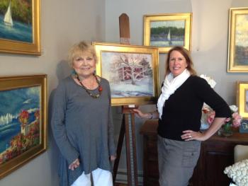 Kathleen Billis, left, and COCO VIVO Fine Art owner Mary Phelps. The Billis work on the easel, “A Northern Farm” in Waldoboro is just one of the new works in a series called, “Feels Like Home” running through August 31. LISA KRISTOFF/Boothbay Register