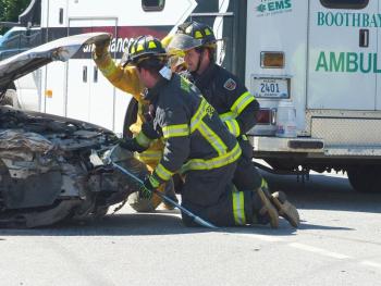 Boothbay Fire Dept. personnel work to open the hood of the Mercury. GARY DOW/Boothbay Register
