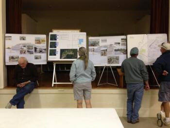Southport residents look over maps and photos of the property and beach at the town meeting. NICOLE LYONS/Boothbay Register