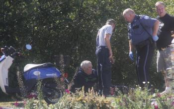 Officer Richard Mirabile talks with accident victim William Anderson sitting on the grass beside Route 96. KEVIN BURNHAM/Boothbay Register