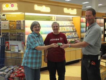 Ames Supply owner Wayne Averill presents gift certificates to winners Sharon Rogers, left, and Patricia Smith.