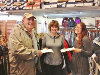 Janson’s Clothing Store owner Betty Maddocks (center) hands out gift certificates to Larry Oakes and Beth Raburn. 