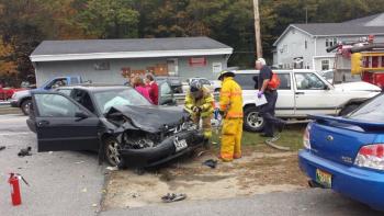 The driver of a black Saab stood near her smashed car shortly after noon Wednesday in Boothbay Harbor. The Saab and a white Jeep Cherokee collided near Hammond Lumber. Although the damage to both cars was substantial, there didn’t appear to be any major injuries. BEN BULKELEY/Boothbay Register