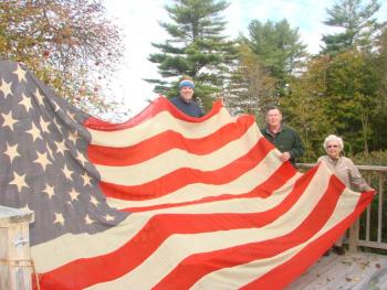 Wiscasset author Phil DiVece, left, Lincoln County Historical Association President Ed Kavanagh and longtime Wiscasset resident Bee King, now of East Boothbay, hold up an 1896 flag King’s grandmother sewed. King donated it to the historical association on October 28. SUSAN JOHNS/Wiscasset Newspaper Wiscasset author Phil DiVece, left, Lincoln County Historical Association President Ed Kavanagh and longtime Wiscasset resident Bee King, now of East Boothbay, hold up an 1896 flag King’s grandmother sewed. King donated it to the historical association on October 28. SUSAN JOHNS/Wiscasset Newspaper