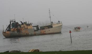 Lobsterman Bill Hallinan tows the Westward back out to its mooring off Signal Point after it had broken loose sometime Thursday morning. KEVIN BURNHAM/Boothbay Register