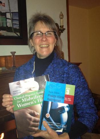 Nell Tharpe, MS, RN, CNM, CRNFA, with copies of the U.S. and Indonesian versions of “Clinical Practice Guidelines for Midwifery & Women's Health,” co-written with Cindy L.Farley. LISA KRISTOFF/Boothbay Register