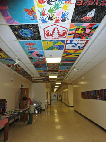The hallway outside the art room shows tiles going down to the very end. Jessica Nadeau rearranges art displays in the hallway. KATRINA CLARK/Boothbay Register