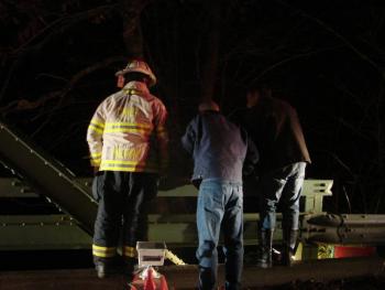Wiscasset Fire Chief T.J. Merry, left, an unknown man and Alna Assistant Fire Chief Roger Whitney look down to where fellow rescuers were returning down a banking and into the water. SUSAN JOHNS/Wiscasset Newspaper