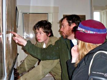 Visitors to the Boothbay Region Historical Society open house study the map of Boothbay Harbor from the early 1800s. KATRINA CLARK/Boothbay Register