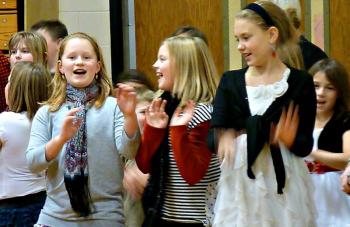 Three fourth-grade girls cut loose during the singalong of “We Wish You a Merry Christmas.” KATRINA CLARK/Boothbay Register