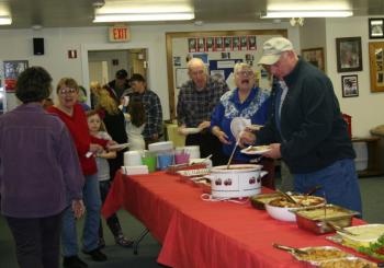 Jim Bryer and others dig in at the buffet table. KEVIN BURNHAM/Boothbay Register
