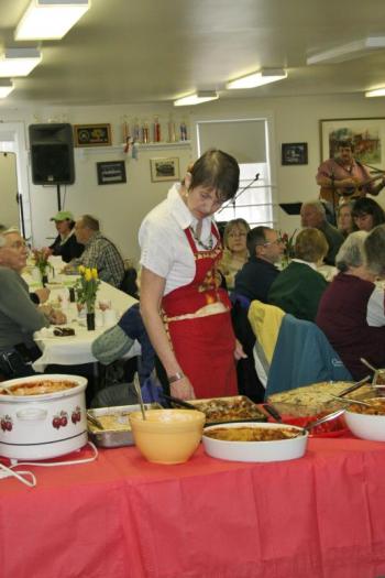 Bonnie McKenney checks the buffet table to see what needs to stay and what’s been gobbled up. KEVIN BURNHAM/Boothbay Register