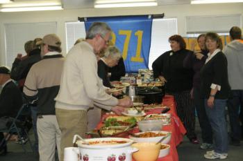 Bob Boyd, after buying his raffle tickets, fills his plate with food. KEVIN BURNHAM/Boothbay Register