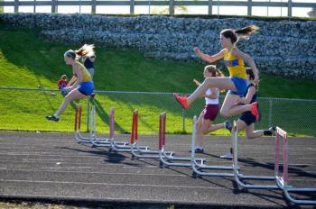 Sinead Miller and Angie Perkins clear the hurdles in the 300m event. Perkins placed third and Miller fifth. Courtesy of Karl Alamo Photo of Sinead Miller and Angie Perkins