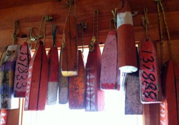 OLD WOOD BUOYS adorn walls and posts at the new shop in town, Nauticalia. SUZI THAYER/Boothbay Register