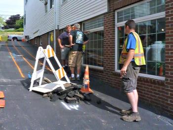 The alleyway between Coastal Maine Popcorn and A Silver Lining is marked with chalk and hazard signs as the Public Works crew figures out where the damage is. KATRINA CLARK/Boothbay Register