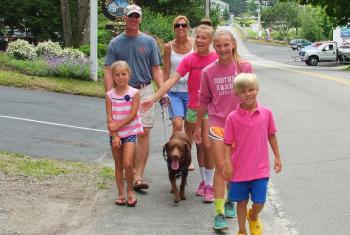 THE PENKIUNAS FAMILY, from Alexandria, Va., walks down Atlantic Avenue on July 3 from a house they are renting. From front left are: Lydia, Algis, Kathy, Anna, Mia, and Lydia’s twin brother, Kaz. And that’s Oliver in the middle. The Penkiunases have been coming to the harbor for visits for 15 years. SUZI THAYER/Boothbay Register