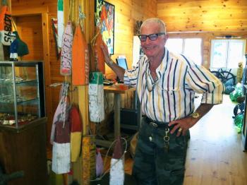GENE DAMON, one of the owners of the new shop, Nauticalia, with some of his old wooden buoys. SUZI THAYER/Boothbay Register