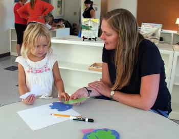 ALEXANDRA PINKHAM, Head Teacher at the new Montessori School, helps Shea Fritz make a choice of which color fish to use in a project. SUZI THAYER/Boothbay Register