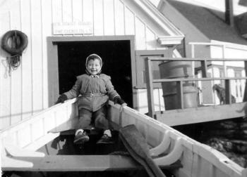 KATHLEEN EYLES sits in a boat on the ramp leading up to the boathouse during the time her parents were keepers at the Cuckolds Light Station in 1955. Courtesy of Kathleen Eyles