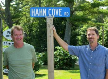 Robert, left, and Mike Hahn, visiting Maine from California for the first time, stand next to the McKown Point road sign honoring their ancestors. Courtesy of Stephen Rubicam