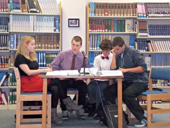 A table studies their notes to figure out how to answer a question during the juniors debate. From left: Gretchen Elder as a representative of The Maine Heritage Foundation, Nick Gorey as Gov. Paul LePage, Sam Betts as Sen. Olympia Snowe and Gabe Purin as a small business owner. KATRINA CLARK/Boothbay Register