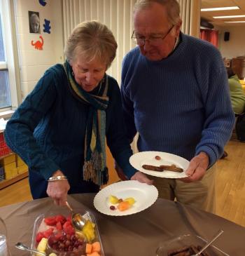 Dee and Howard Wright serve themselves fruit and sausage at the Active Older Adults breakfast at the YMCA on Nov. 17. SUZI THAYER/Boothbay Register