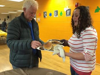 Bruce MacDonald helps himself to some pancakes offered by Rose Mooney. SUZI THAYER/Boothbay Register
