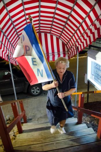Waitress Cheryl Rice brings in the "Open" flag for the last time as the Ebb Tide restaurant closes Thursday night after exactly 40 years of operation. Courtesy of Peter Southwick