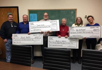 Four local charities were presented checks on Dec. 16 at the Boothbay Elementary School, from McSeagull’s Thanksgiving fundraiser. McSeagull’s employee Jeff Stoddard, left, and manager Alyssa Allen, right, presented the checks to: Tom Wilson (second from left) for the Food Pantry; Elementary School Principal Mark Tess for Santa’s Elves; Peggy Peters for Meals on Wheels; and Sarah Foulger for Food for Thought. SUZI THAYER/Boothbay Register