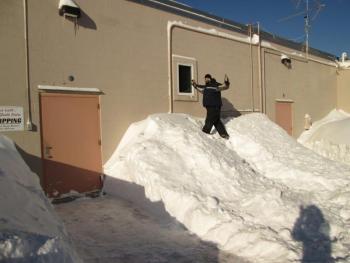 Tom Dewey, after shoveling out the back door at Harbor-Tech Solutions, climbs the snowbank to peer into Russell Brackett’s office. Courtesy of Leisha J. MacDougall.